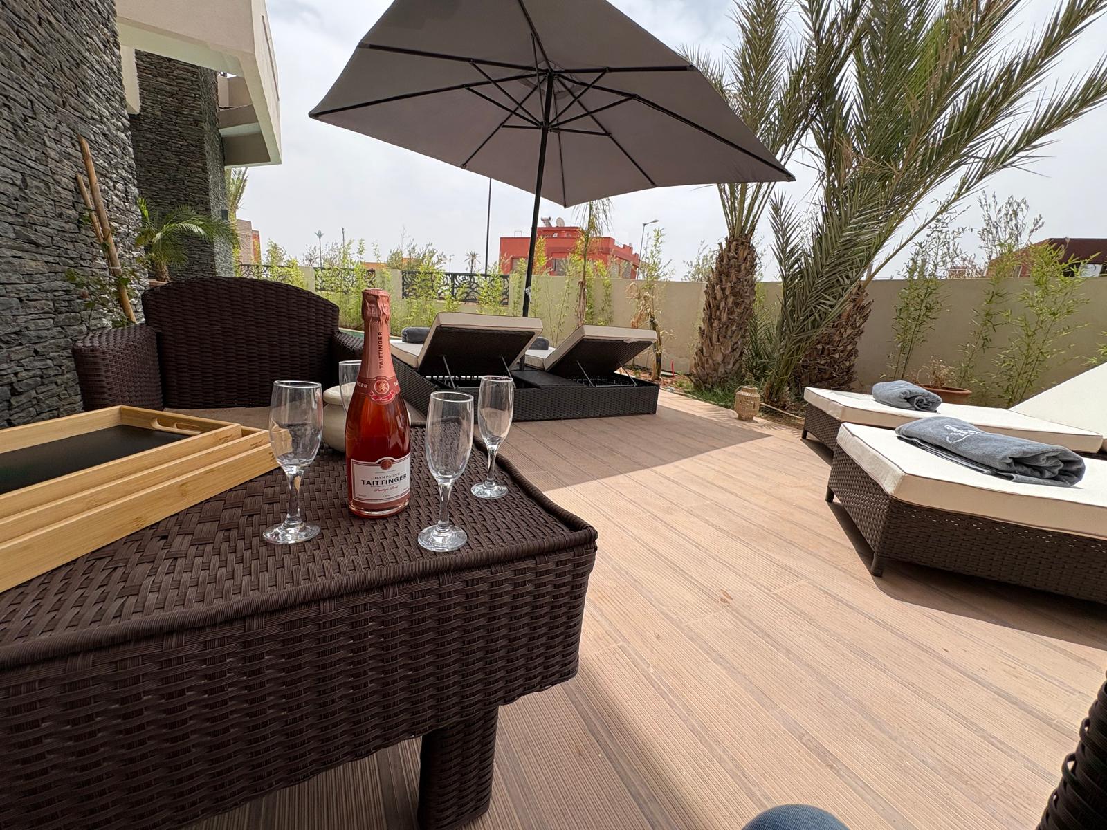 Terrasse avec parasol au bord de la piscine